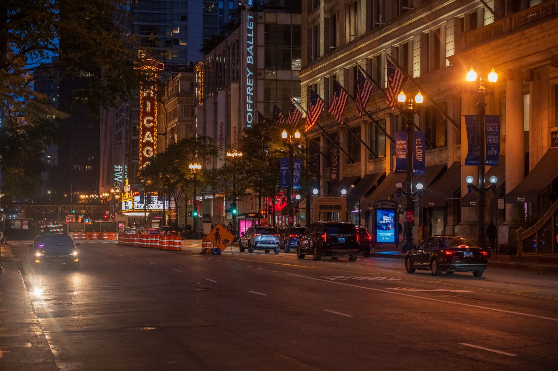 View of a bustling Chicago street at night featuring the iconic Chicago Theater sign and urban nightlife.