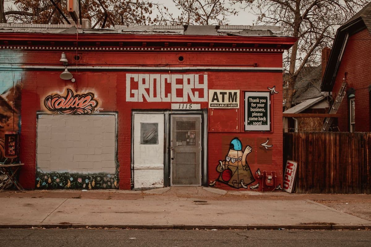 Vivid urban storefront with graffiti and 'GROCERY' signage. Artistic street scene.